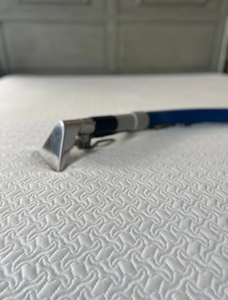 Extraction tool steam cleaning a white mattress